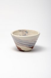 Ceramic cup with swirling patterns in shades of gray and white.