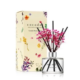 Rose-scented reed diffuser with pink floral accents in a glass container.