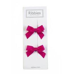 Hot pink hair bows with a bow shape and ribbon texture.