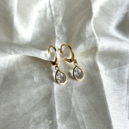  Elegant gold-tone hoop earrings with teardrop-shaped crystal accents. Suitable for formal or casual wear.