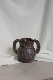 A handmade, matte gray vase with a simple, cylindrical shape.