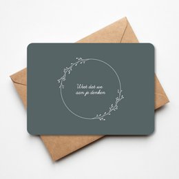 Greeting card with a simple floral wreath design and the text "When all we can give is our prayers" printed on a dark gray background.