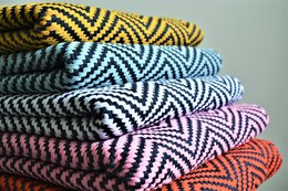Vertical striped throw blanket in various color combinations including grey/orange, grey/yellow, grey/white, grey/skyblue, and grey/pink. The throw measures 130 x 180 cms.