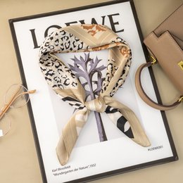  A square silk scarf with a graphic jungle print in shades of beige, brown, and black. The scarf has a silk-like texture and a classic square shape, making it a versatile accessory for any outfit.