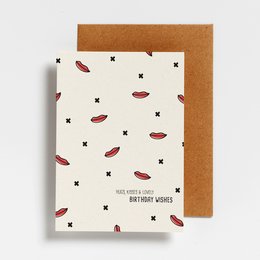 Postcard with a pattern of red lips and stars on a white background, with a brown envelope.