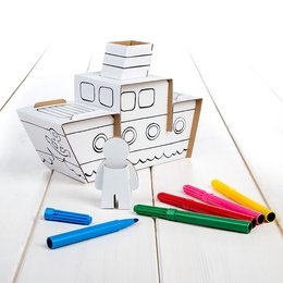 A white cardboard steamboat with colorful markers and crayons, suggesting a creative arts and crafts project.