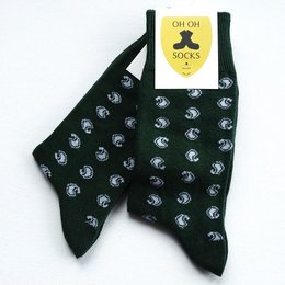 Black socks with a repeating pattern of white clover shapes, featuring a yellow label with the brand name "Prestige" printed on it.