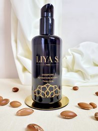 Organic ylang ylang shampoo in a dark glass bottle with a floral design. Suitable for hair repair and intense nourishment.