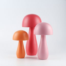 Decorative mushroom-shaped objects in vibrant colors including orange, pink, and candy pink. The objects have a rounded, dome-like shape and appear to be made of a smooth, glossy material.