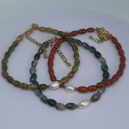 Oval gemstone and freshwater pearl bracelet in moss agate, unakite, and red jasper colors.

The bracelet features a mix of oval-shaped gemstones in various colors, including moss agate, unakite, and red jasper, interspersed with freshwater pearls. The bracelet has a gold-tone chain and clasp, adding a touch of elegance to the natural, earthy tones of the stones.