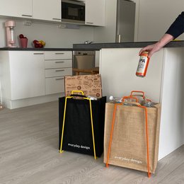 Orange paper bag holder with sturdy handles for storing and organizing kitchen items.