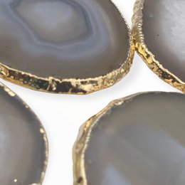 Natural agate coasters with gold trim, round shape, decorative home accessory.