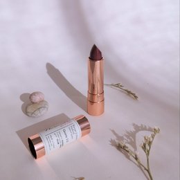 Natural lipstick in a rose gold tube with a pink, glossy finish.