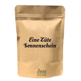 A bright yellow sunflower in a paper bag labeled "Eine Tüte Sonnenschein" (A Bag of Sunshine). The sunflower is a cheerful and vibrant garden product.