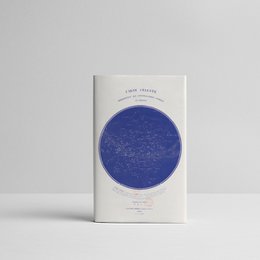 A celestial map notebook featuring a detailed illustration of the night sky. The notebook has a blue cover with a circular celestial map design, showcasing the constellations and stars.