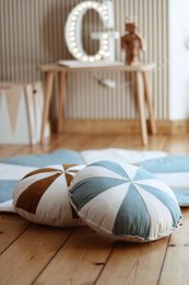 "Patchwork cushion in shades of blue, featuring a round, plush design with a textured surface. Suitable for use as a decorative accent or floor cushion in a cozy, modern living space."