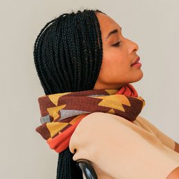 Warm, patterned infinity scarf in shades of brown, orange, and yellow. Made of soft, cozy material.