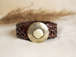 Small brown leather belt with metal buckle, packaged in a polka dot gift box.