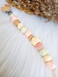 Pacifier cord with colorful beads in various shapes and patterns, including round, square, and heart-shaped beads in pastel shades of pink, yellow, and white.