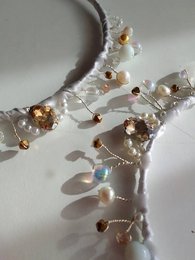 Elegant white headband with sparkling crystal and pearl accents, featuring a delicate floral design.