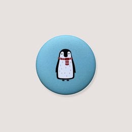 Round blue magnet with penguin wearing red scarf, cute animal design refrigerator magnet.