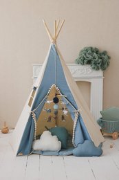  A blue and white teepee tent with pompoms, designed for kids' play. The tent features a triangular shape, white clouds, and hanging decorations.