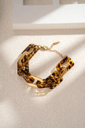  Elegant gold-toned chain bracelet with resin and stainless steel accents in a chic, trendy design.