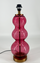 A tall, round table lamp with a vibrant pink glass base. The lamp has a classic, elegant design with a black lamp shade.