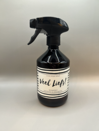 Cream-colored room spray with a black and white striped label that says "Veel lief!" in cursive text. The spray bottle has a black trigger sprayer.