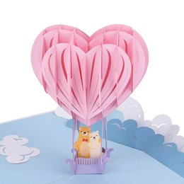 A pop-up card featuring a pink heart-shaped hot air balloon carrying a cute stuffed animal. The card is suitable for various occasions and can be used to express love, appreciation, or celebrate special events.