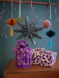  Plum diamond and gold moon patterned furoshiki wrapping paper, with vibrant purple and gold gift boxes and decorative hanging ornaments.