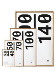 This frame is made of oak and acrylic glass, available in sizes 30x40, 50x70, 70x100, and 100x140 cm. The simple, minimalist design features bold black numbers on a white background, making it a versatile piece that can complement a variety of decor styles.