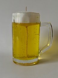 A tall, cylindrical glass beer mug filled with golden-colored beer.