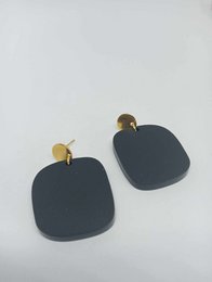  Black matte acrylic drop earrings with gold-tone hardware.