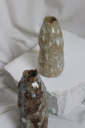 A handmade, matte gray vase with a simple, cylindrical shape.