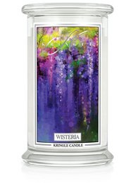 Tall, round scented candle with a floral, wisteria fragrance. Features a vibrant purple and green color palette.