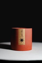 Tall, round concrete candle with a star design on the label, available in a scented variety.