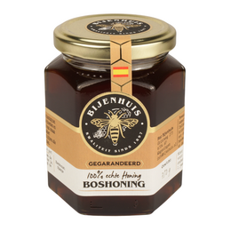 A jar of rich, golden-colored forest honey with a natural, earthy flavor. The honey is packaged in a glass jar with a metal lid.