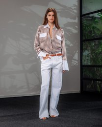  A striped button-up blouse with long sleeves and a collared neckline. The blouse has a relaxed, casual style and is suitable for women's casual or business casual wear.