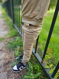 Beige jogger pants for boys, featuring a drawstring waist and ribbed cuffs for a comfortable fit. Suitable for casual everyday wear.