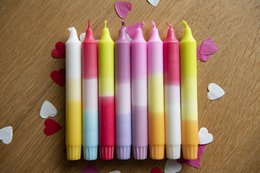  Colorful, multi-dipped candles in various pastel shades including pink, yellow, and purple. The candles have a unique, layered design with a tapered shape.