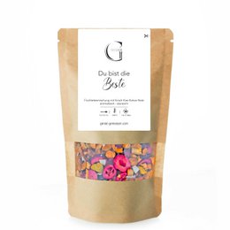 A blend of dried fruit and spices, including orange peel, cinnamon, and cloves, in a round tea tin.