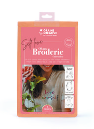 Embroidery kit for a women's t-shirt with a "Self Love" design. The kit includes an embroidery hoop, embroidery floss, and a pre-printed fabric panel.