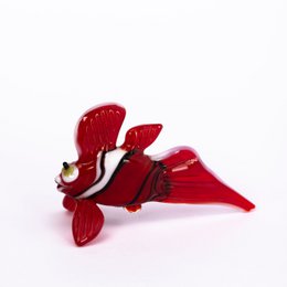 Glass Caribbean fish statue in a vibrant red color with a unique, abstract fish-like shape.