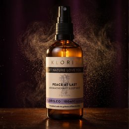  Soothing mist aromatherapy sleep spray in a glass bottle with a wooden leaf-shaped tray. The spray is labeled "Kloris" and contains natural ingredients to promote relaxation and sleep.