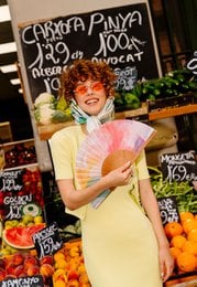 Vibrant pink shorts with a flowing, floral-patterned top. The outfit has a bohemian, festival-inspired style.