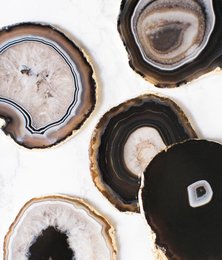 Black agate coasters with natural stone patterns and textures. Decorative round coasters made from natural agate stone.