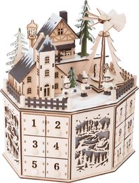 Wooden advent calendar with pyramid design, featuring a winter village scene with houses, trees, and a windmill. The calendar has numbered doors for each day leading up to Christmas.
