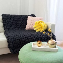 Chunky knit anthracite wool blanket, available in medium (100x150cm), small (80x130cm), XL (150x203cm), and L (130x180cm) sizes. The blanket has a cozy, textured appearance with a solid, dark color.