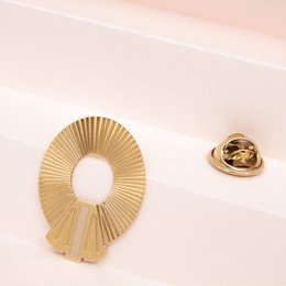 Elegant gold-toned brooch with a sunburst design, available in a variety of colors including blanc, nude, mousse, noir, ambre, brique, midnight blue, prusse, corail, aniline, sable, and massaï.